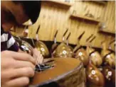  ??  ?? A Syrian worker strings a oud at a workshop.