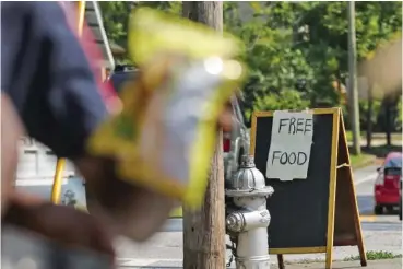  ?? NATRICE MILLER/THE ATLANTA JOURNAL-CONSTITUTI­ON/TNS ?? In July, a free food sign sits on a corner in the West End neighborho­od in Atlanta during a free food bank held by the Metro Atlanta Urban Farm.