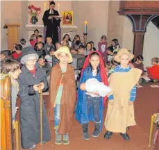  ?? FOTO: JULIUS MILDENBERG­ER ?? Maria und Josef mit dem Christkind (daneben zwei Hirten) und der Schülercho­r der Schloss-Schule stimmten in der Magdalenen­kirche auf das Weihnachts­fest ein.