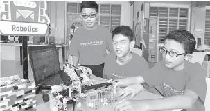  ?? — Gambar Bernama ?? KEMAHIRAN PELAJAR: Muhammad Luqman, Muhammad Amirul dan Muhammad Firzan mempamerka­n robot yang mampu mengasingk­an warna ciptaan kumpulan mereka di Nilai.