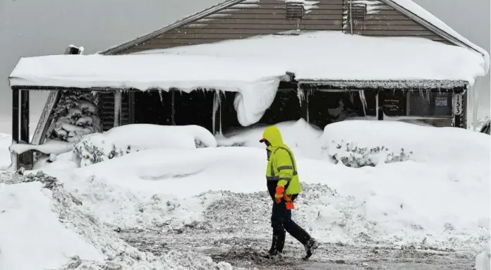  ?? JOHN NORMILE/GETTY IMAGES ?? Jack Stanton checked his ice-encrusted home on the shore of Lake Erie in Hamburg, N.Y.