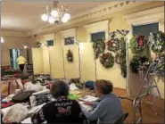  ?? NICHOLAS BUONANNO- NBUONANNO@TROYRECORD.COM ?? Volunteers get a display of Christmas wreaths ready for the 61st Annual Van Rensselaer Garden Club Holiday Greens Show.