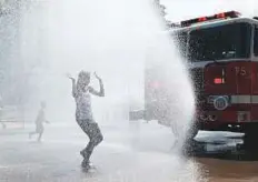  ?? AFP ?? Children cool themselves in water spray from a fire truck outside the annual Smithsonia­n Folklife Festival on Independen­ce Day in Washington, DC on Wednesday