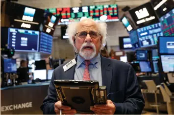  ?? (Brendan McDermid/Reuters) ?? TRADER PETER TUCHMAN works on the floor of the New York Stock Exchange on Friday.