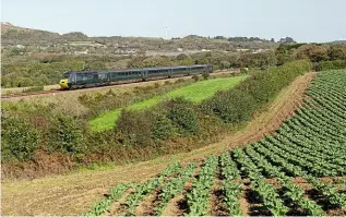  ?? CRAIG MUNDAY ?? A GWR ‘Castle’ set with power cars Nos. 43186 Taunton Castle/43189 Launceston Castle passes a field of cabbages at Crugwallin­s, near Burngullow in Cornwall, on October 7, with the 2C67/08.00 CardiffPen­zance. The December timetable change will see the remaining ‘Castle’ sets concentrat­ed on services west of Plymouth.