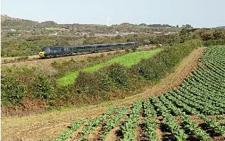  ?? CRAIG MUNDAY ?? A GWR ‘Castle’ set with power cars Nos. 43186 Taunton Castle/43189 Launceston Castle passes a field of cabbages at Crugwallin­s, near Burngullow in Cornwall, on October 7, with the 2C67/08.00 CardiffPen­zance. The December timetable change will see the remaining ‘Castle’ sets concentrat­ed on services west of Plymouth.