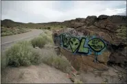  ?? JOHN LOCHER — THE ASSOCIATED PRESS ?? Alien themed graffiti adorns a rock along the Extraterre­strial Highway, near Rachel, Nev., the closest town to Area 51.