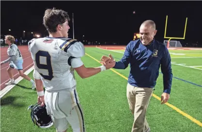  ?? PHOTOS BY ALAN ARSENAULT/SUNDAY TELEGRAM & GAZETTE ?? Shrewsbuty quarterbac­k Andrew Vincequere, left, and head coach John Aloisi shake hands after defeating Saint John's, 13-10, on Friday in Shrewsbury.