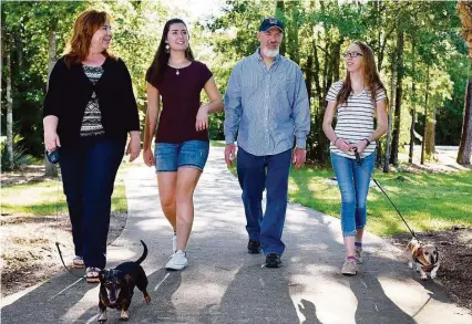  ?? Jerry Baker ?? Dina Ohlemeier, left, joins College Park High School junior and foreign exchange student Juli Wiethoff, her husband Lane and their daughter Avery, also a junior at College Park, on a walk near their home in The Woodlands.