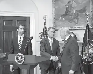  ?? Zach Gibson/Pool/Sipa USA/TNS ?? President Donald Trump shakes hands with Sen. David Perdue, R-Ga., during an announceme­nt on the introducti­on of the Reforming American Immigratio­n for a Strong Economy Act on Aug. 2 in the Roosevelt Room at the White House in Washington, D.C. At left...