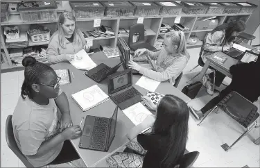  ?? NWA Democrat-Gazette/DAVID GOTTSCHALK ?? Armoni Rodgers (clockwise from left), Allyson Owen, Aniston Gotcher and Kaylee Hodge, all sixth-grade students in the Medical Detection class of Marianne Sanders at Holt Middle School, use their Chromebook­s on Wednesday to work on an assignment in...