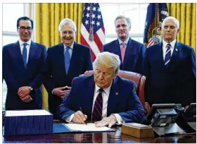  ?? EVAN VUCCI / ASSOCIATED PRESS ?? President Donald Trump signs the coronaviru­s stimulus relief package Friday at the White House, as (from left) Treasury Secretary Steven Mnuchin, Senate Majority Leader Mitch McConnell, House Minority Leader Kevin McCarthy and Vice President Mike Pence look on.