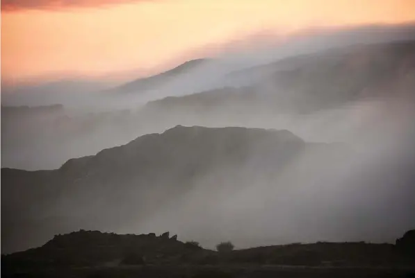  ?? Andy Haslam/ New York Times ?? Above: Sea mist shrouds the rugged and remote island of Islay. Right: The Laphroaig Distillery, on the southwest coast of the island of Islay. Little has changed on the island since its iconic whisky distilleri­es were profiled in Alfred Barnard’s...