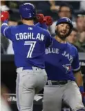  ?? KATHY WILLENS/THE ASSOCIATED PRESS ?? Kevin Pillar, right, congratula­tes third baseman Chris Coghlan after the latter’s sixth-inning solo home run.