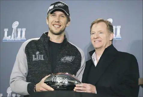  ?? Chris Carlson/Associated Press ?? NFL commission­er Roger Goodell, right, and Eagles quarterbac­k Nick Foles pose with Foles’ Super Bowl MVP trophy at a news conference Monday. The Eagles defeated the Patriots, 41-33, to win the 2018 Super Bowl on Sunday.
