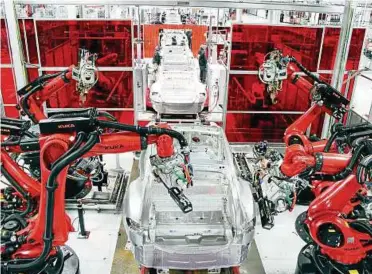  ??  ?? Blick in die Tesla-Produktion in San Francisco: Die Montage am Band erfolgt maßgeblich durch Roboter. Foto: imago