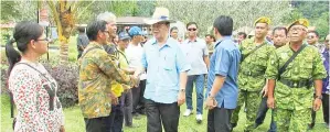  ??  ?? RADIN bersalaman dengan penduduk kampung sebaik tiba di majlis itu.