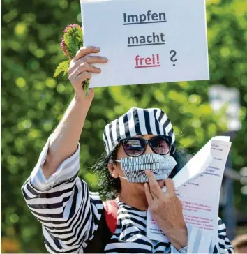  ?? Symbolfoto: Boris Roessler, dpa ?? Antisemiti­smus und eine Verharmlos­ung der Holocausts: In KZ‰Häftlingsk­leidung und mit dem Schild „Impfen macht frei“, das an das Nazi‰Motto „Arbeit macht frei“erinnert, demonstrie­rt diese Frau gegen die Corona‰Politiker.