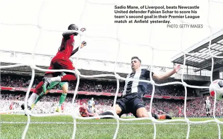  ?? PHOTO: GETTY IMAGES ?? Sadio Mane, of Liverpool, beats Newcastle United defender Fabian Schar to score his team’s second goal in their Premier League match at Anfield yesterday.