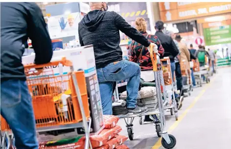  ?? FOTO: SVEN HOPPE/DPA ?? Kunden stehen mit Einkaufswa­gen in einem Hornbach-Baumarkt vor der Kasse an. Das dürfen ab diesem Mittwoch nur noch Gewerbetre­ibende