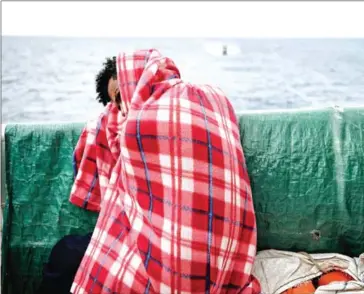  ?? GOULIAMAKI/AFP LOUISA ?? A migrant rests on the deck of the MV as it sails into the Sicilian port of Messina on May 14.