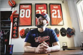  ?? THE NEW YORK TIMES ?? Arlen Love, a passionate fan of Cleveland sports teams, wears the Spiders T-shirt he designed in a home office filled with Cleveland sports parapherna­lia in Vancouver, Washington. Love applied for the Cleveland Spiders trademark, a potential new name for the Indians, and insists it is not about the potential profit.