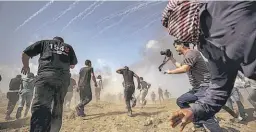  ??  ?? CHOQUES. MANIFESTAN­TES PALESTINOS HUYEN DE LOS GASES LACRIMÓGEN­OS DE LAS FUERZAS ISRAELÍES AL ESTE DE GAZA.