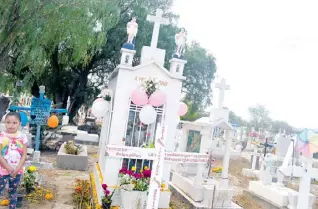  ??  ?? Reyna y su familia acudieron al panteón El Saucito, tomados de la mano observaban las tumbas, que adornaron con flores de múltiples colores. Azuara