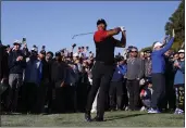  ?? RYAN KANG — THE ASSOCIATED PRESS ?? Tiger Woods hits his approach shot off the fairway on the first hole during the final round of the Genesis Invitation­al at Riviera Country Club on Sunday in the Pacific Palisades area of Los Angeles.