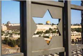  ??  ?? Jerusalem’s Old City is seen trough a door with the shape of star of David. | ODED BALILTY/ AP