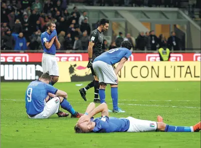  ?? MAX ROSSI / REUTERS ?? Disconsola­te Italy players react to missing next year’s World Cup finals as a result of Monday’s 0-0 draw with Sweden in the second leg of their qualifying playoff at San Siro Stadium in Milan. Sweden advanced 1-0 on aggregate.