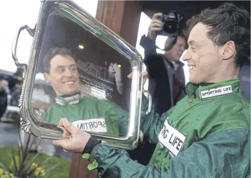  ?? PICTURE: NIALL CARSON/PA ?? Jockey J J Slevin celebrates with the trophy after winning the Boylesport­s Irish Grand National Chase on Intense Raffles yesterday