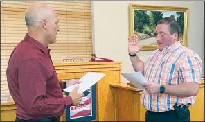  ?? Photo by Poteau Mayor Scotty White ?? City of Poteau Attorney Marc Bovos, left, swears in Poteau Police Department Det. Billy Hooper as the new chief of police after Monday night’s Poteau City Council meeting at Poteau City Hall. Hooper succeeds Poteau P.D. Chief Stephen Fruen, whose resignatio­n was approved by the City Council.