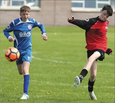  ??  ?? James McCabe of Slane Wanderers can’t stop Drogheda Town’s Darragh McGuinness from clearing the ball during Sunday’s Under-12 game at St Oliver’s CC.