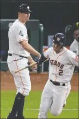 ?? The Associated Press ?? CARRYING IT TOO FAR: Houston Astros’ Alex Bregman hand his bat to first base coach Don Kelly after a home run Tuesday against the Washington Nationals during the first inning of Game 6 of the World Series in Houston.