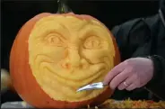  ?? Oli Scarff
AFP ?? /
Jamie Wardley, director of artistic company Sand in Your Eye, puts the finishing touches to a carved pumpkin in Hebden Bridge, northern England, on Friday. Jack-o’-lanterns have come a long way since the beginnings of the Irish myth.