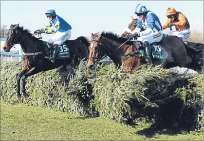  ??  ?? Auroras Encore and Ryan Mania (left) jump into the lead at the final fence in the John Smith’s Grand National.