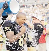  ?? JOHN RAOUX/ORLANDO SENTINEL ?? UCF quarterbac­k Daunte Culpepper, left, gets doused with water by his teammates during his record-setting tenure leading the Knights.