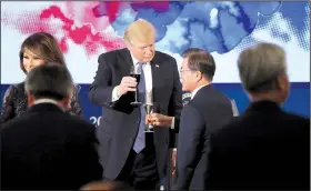  ?? AP/ANDREW HARNIK ?? President Donald Trump shares a toast with South Korean President Moon Jae-in before a state dinner Tuesday in Seoul. Trump softened his rhetoric on North Korea as he met with Moon.