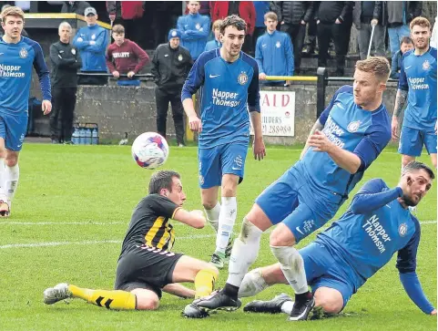  ??  ?? Lochee United (blue) defend in numbers during their Scottish Cup semi-final first leg at Auchinleck. Pic by Paul Flynn.