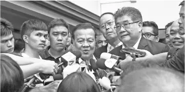  ?? — AFP photo ?? Viroj Pao-in (centre) speaks to journalist­s after being named the leader of PueaThai party in Bangkok.