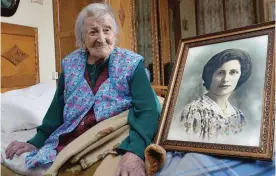  ??  ?? VERBANIA: Emma Morano poses next to a picture depicting her when she was young. —AP