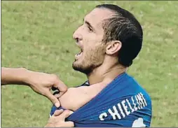  ?? YASUYOSHI CHIBA / AFP ?? Castigo. Chiellini exhibe el mordisco que le propinó Luis Suárez y supuso una dura sanción para el uruguayo