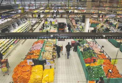  ?? PHILIPPE HUGUEN / AFP VIA GETTY IMAGES / FILES ?? People in Faches-Thumesnil do their shopping at an Auchan supermarke­t, a chain which is basically France's answer
to Walmart and which is owned by the very wealthy Mulliez family.