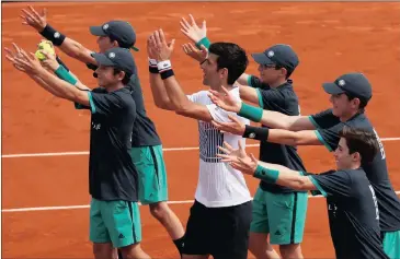  ?? Picture: GONZALO FUENTES, REUTERS ?? NOVAK’S ARMY: Novak Djokovic celebrates winning his first round match at the French Open with ball boys yesterday.