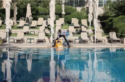  ?? (Marc Israel Sellem/The Jerusalem Post) ?? CLEANING THE empty King David Hotel pool in Jerusalem and waiting for tourists.