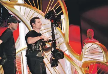  ?? Al Seib Los Angeles Times ?? ROBERT LORENZ, left, and Steadicam operator Tore Livia help prepare for the Oscars show. The telecast has suffered declining ratings, and some in the film industry worry the event holds little sway with the public.