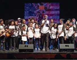  ?? CONTRIBUTE­D PHOTOS ?? How Big Is Your Dream founder and CEO Jorel “JFly” Flynn joins student artists on stage after they performed their last song at a recent Academy of the Arts program.