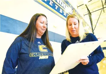  ?? STAFF PHOTO BY MATT HAMILTON ?? UTC women’s basketball coach Katie Burrows, right, goes over a play with her sister and new assistant coach Kristen Clounch on Wednesday at the Brenda Lawson Student-Athlete Success Center. Clounch, a longtime high school coach at Lookout Valley, has joined Burrows’ staff as she prepares for her fourth season as head coach of the Mocs.