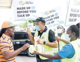  ?? IAN ALLEN/PHOTOGRAPH­ER ?? Health and Wellness Minister Dr Christophe­r Tufton and community health aides hand out COVID-19 sensitisat­ion flyers as they march through the streets of Spanish Town, St Catherine, yesterday to emphasise the importance of masks to containing the coronaviru­s pandemic.